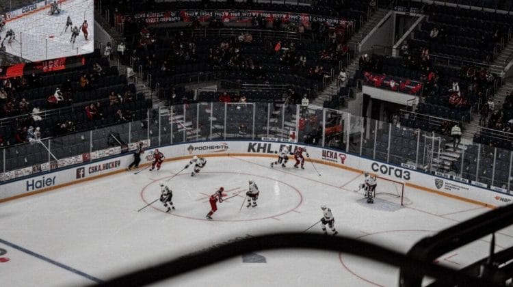 Spectators filled the large indoor arena, eagerly watching NHL hockey as players glided skillfully across the ice.