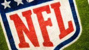 Close-up of the NFL logo painted on a grass field, offering a captivating glimpse into the world of football, perfect for demystifying the NFL for fans and newcomers alike.