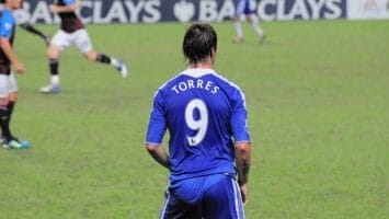 During the match, a soccer player in a blue jersey with the number 9, "Torres," moved swiftly across the field. Meanwhile, Chelsea choked in the derby against West Ham, adding more intensity to an already electrifying game.