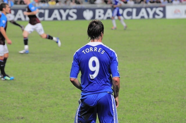 During the match, a soccer player in a blue jersey with the number 9, "Torres," moved swiftly across the field. Meanwhile, Chelsea choked in the derby against West Ham, adding more intensity to an already electrifying game.