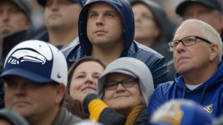 A group of people dressed in rain gear and hats watch an outdoor event in the rain, some looking up attentively, reminiscent of devoted fans from various NFL eras.