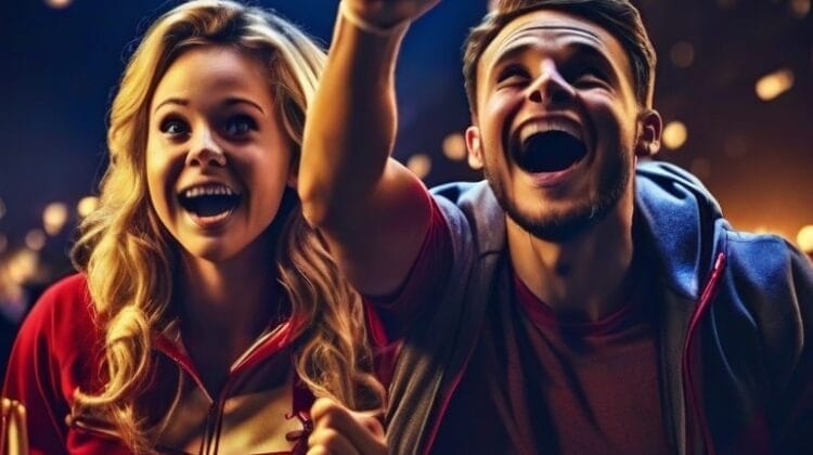 Two people cheer enthusiastically at an NHL Skills Competition event, with string lights illuminating the background. Both wear casual clothing and have joyful expressions.