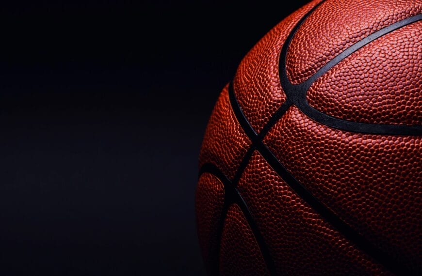 Close-up of a basketball on a dark background, evoking the classic feel of 90s basketball with its textured surface and black seams, reminiscent of the iconic NBA era.