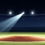 A spotlight shines on an empty baseball pitcher's mound in a stadium at night, echoing the presence of disputed legends in baseball that have left their mark.