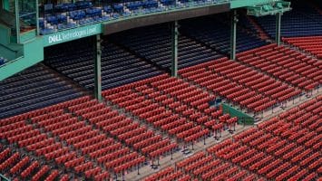 A view of a stadium's seating area reveals rows of red seats in the lower section and blue seats above. Dell Technologies' branding stands out on the green structure, a subtle backdrop amid discussions of MLB rule changes sweeping through the baseball community.