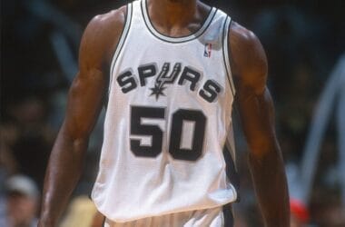 Basketball player in a Spurs jersey numbered 50, reminiscent of NBA legend David Robinson, standing on a court.